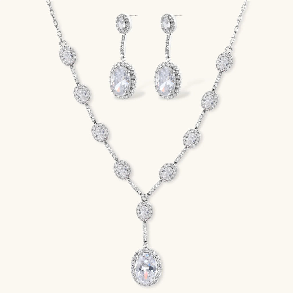 Elegant white gold plated jewelry set with oval cubic zirconia stones in halo settings, featuring Y-necklace and drop earrings.