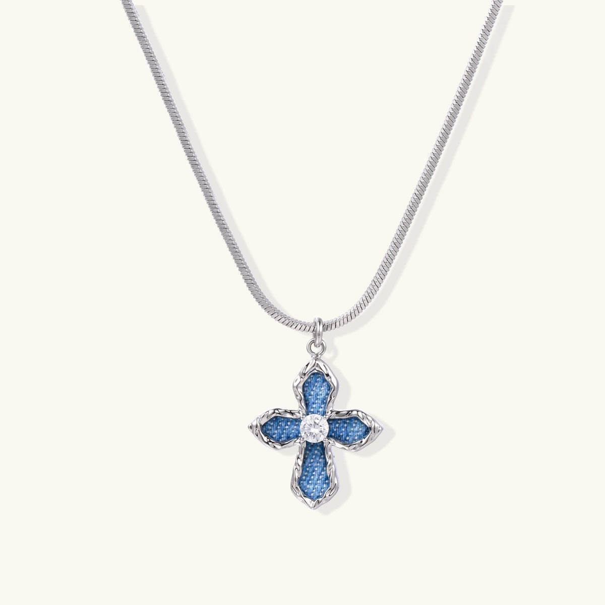White gold plated cross pendant with blue denim fabric inlays and central zirconia crystal on adjustable chain