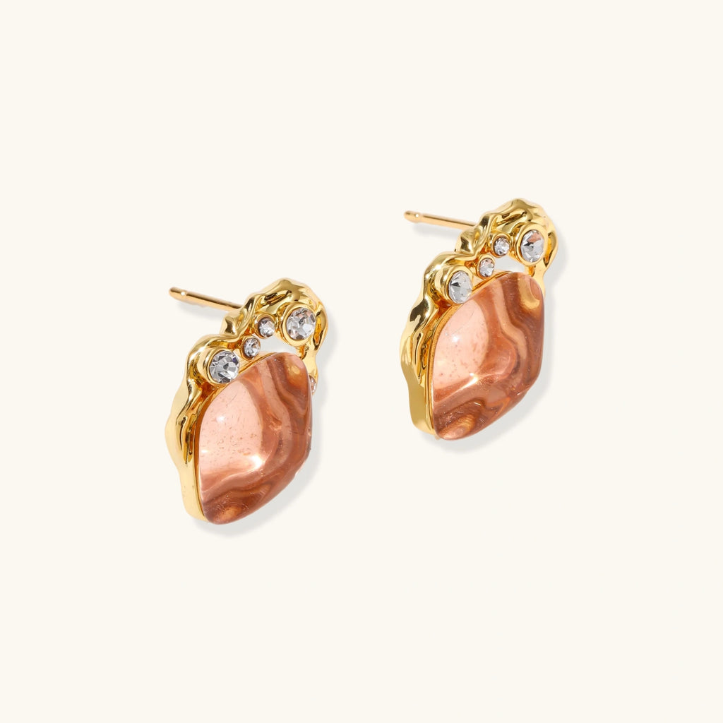 Gold-plated baroque stud earrings with coral-pink liuli stones and cubic zirconia crystals on white background.